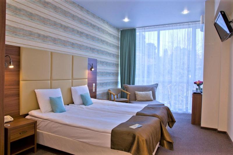 a hotel room with a large bed and a window at Sochi-Breeze Spa Hotel in Sochi