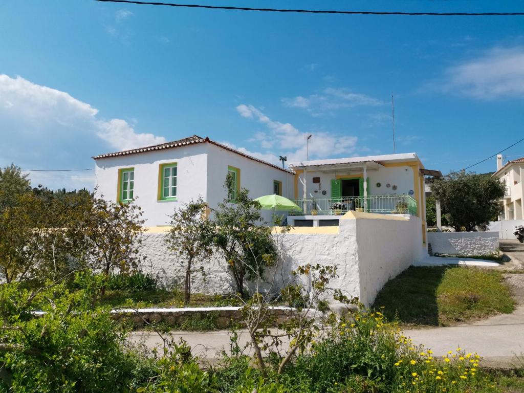 uma casa branca com uma porta verde em Vaggelis Traditional House em Spetses