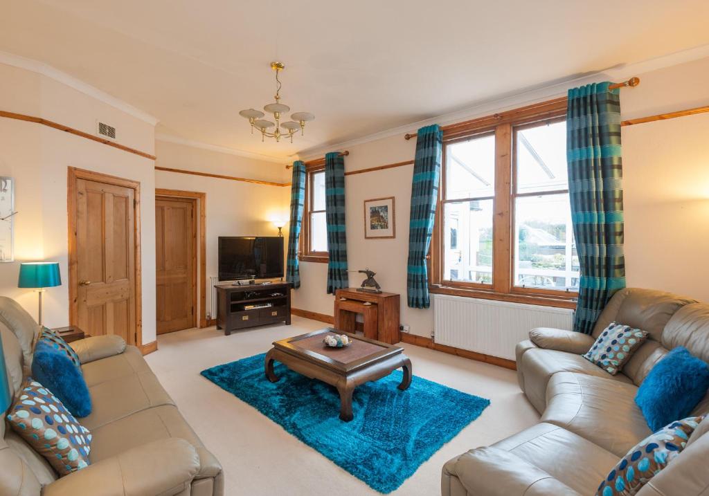 sala de estar con sofá y mesa de centro en The Traquair Park Residence, en Edimburgo