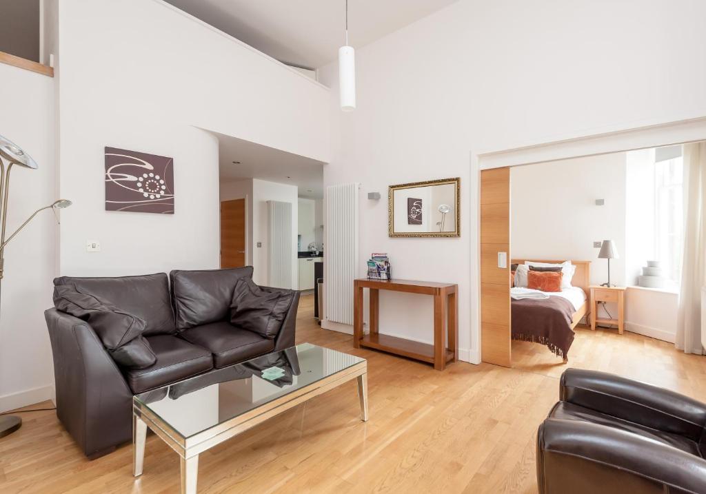 uma sala de estar com um sofá e uma mesa em The Quartermile Meadows View Residence em Edimburgo