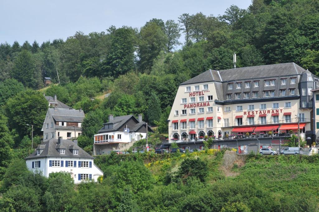 a group of buildings on a hill with trees at Hotel Panorama in Bouillon