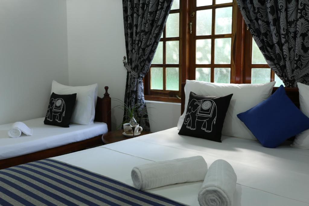 um quarto com uma cama com almofadas e uma janela em Amsterdam Tourist Rest em Anuradhapura