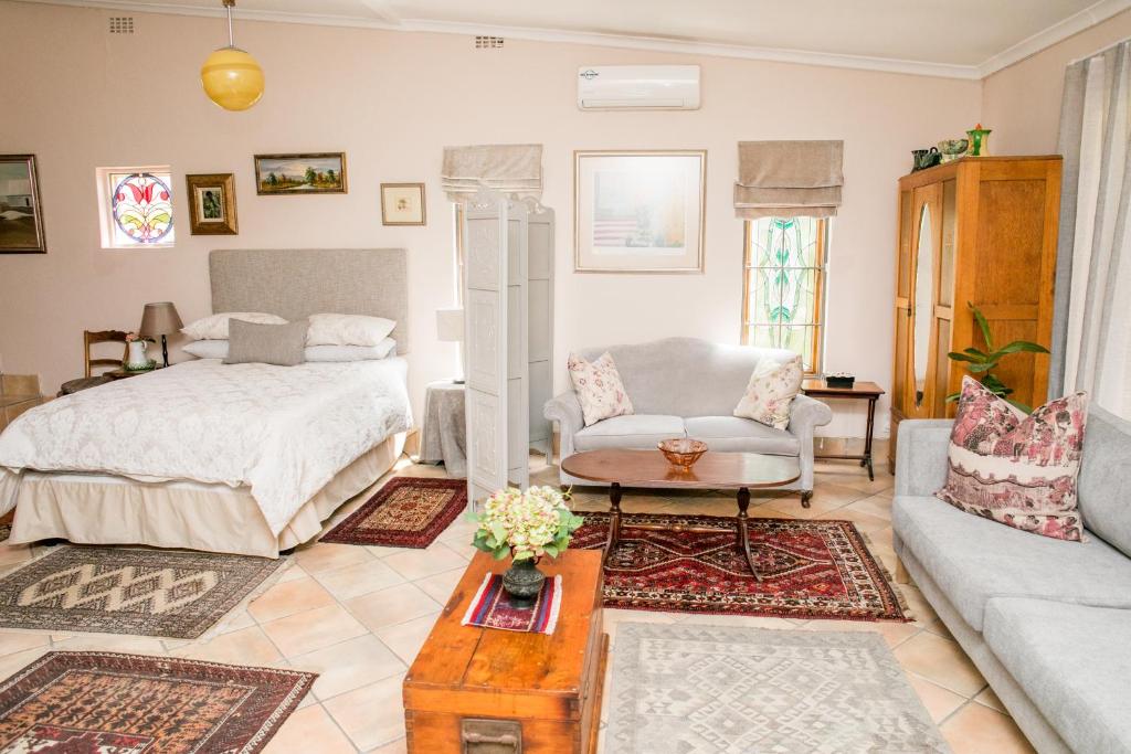 a living room with a bed and a couch at Villa Pascal Guest House in Durbanville