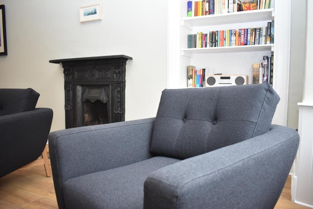 a blue couch in a living room with a fireplace at High Street - modern Scandi design apartment in the heart of the old town! in Edinburgh