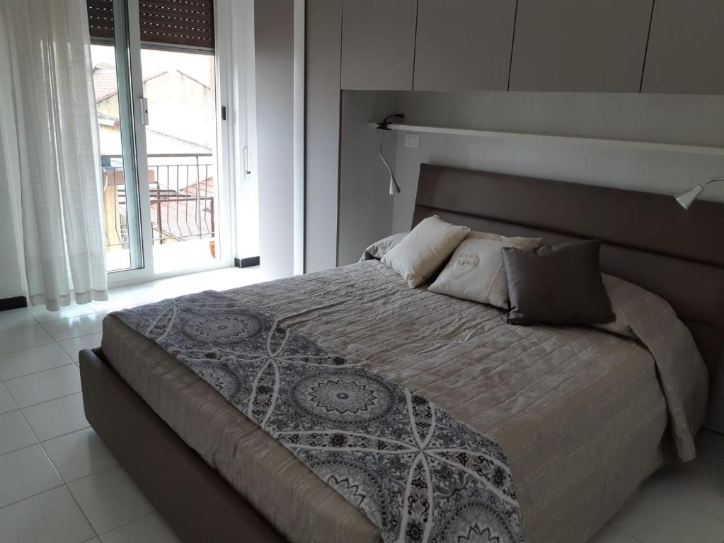 una camera da letto con un grande letto con una grande finestra di APPARTAMENTO nonni FRANCHI a Loano