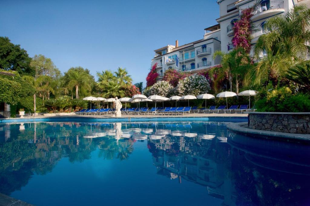a swimming pool in front of a hotel at Sant Alphio Garden Hotel & SPA in Giardini Naxos