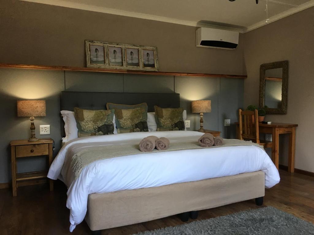 um quarto com uma cama grande e toalhas em African Dawn B&B em Calvinia