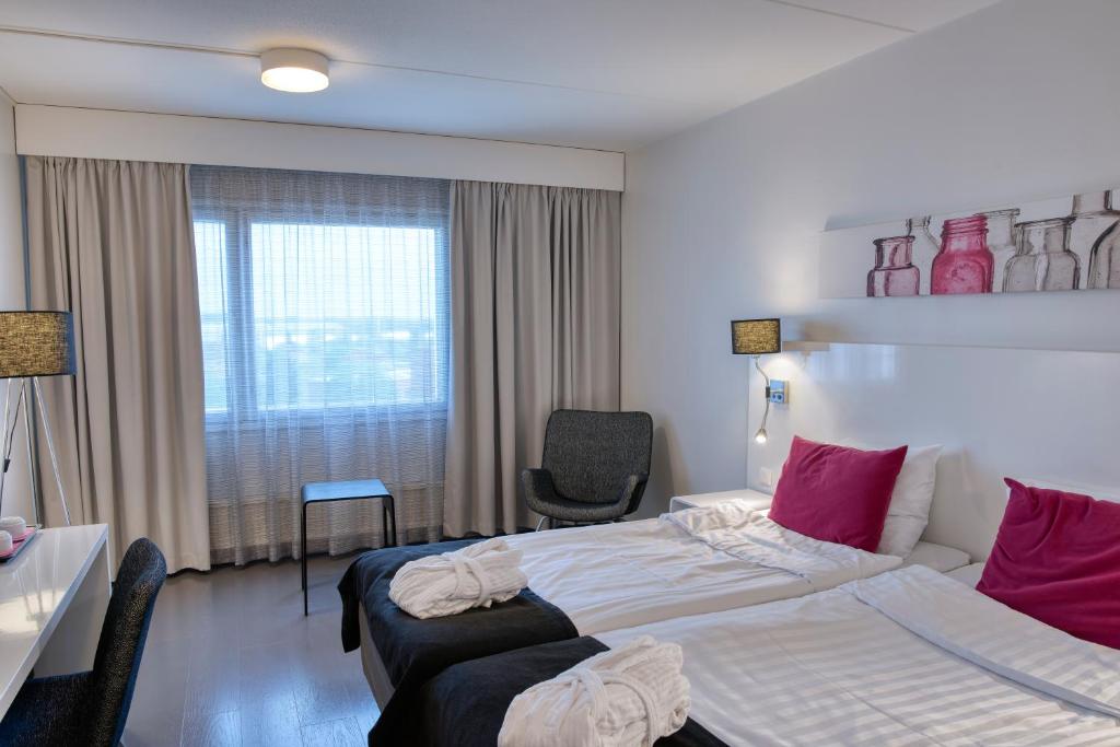 um quarto de hotel com uma cama grande e uma janela em Teatterihotelli Riihimäki em Riihimäki