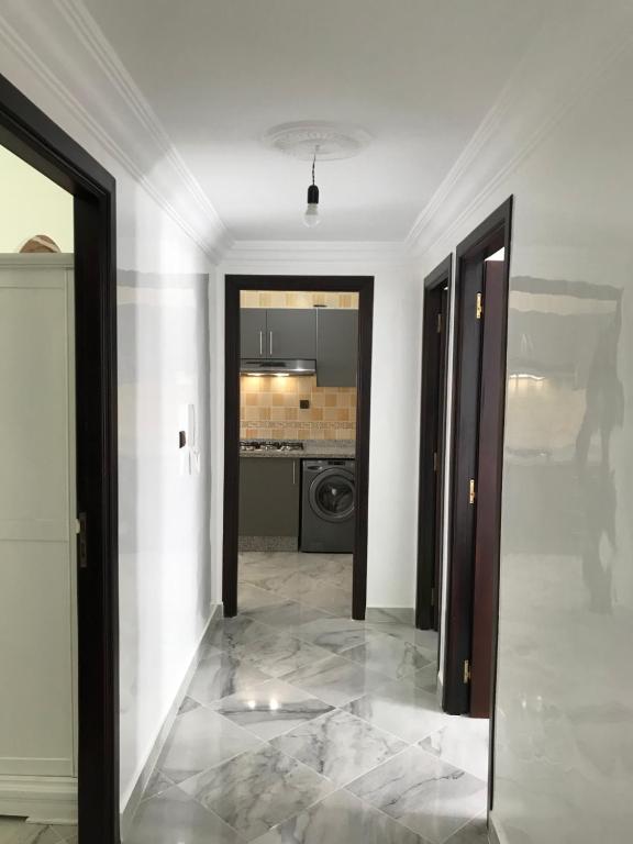 Tetouan Relax Apartement في تطوان: ممر مع مرآة في غرفة بيضاء