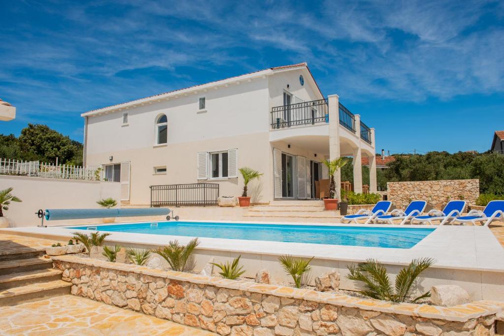 a villa with a swimming pool and a house at VILLA Temida Premuda in Premuda