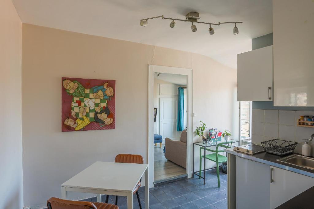 cocina y sala de estar con mesa en Nid Cosy - Lyon 6e, en Lyon