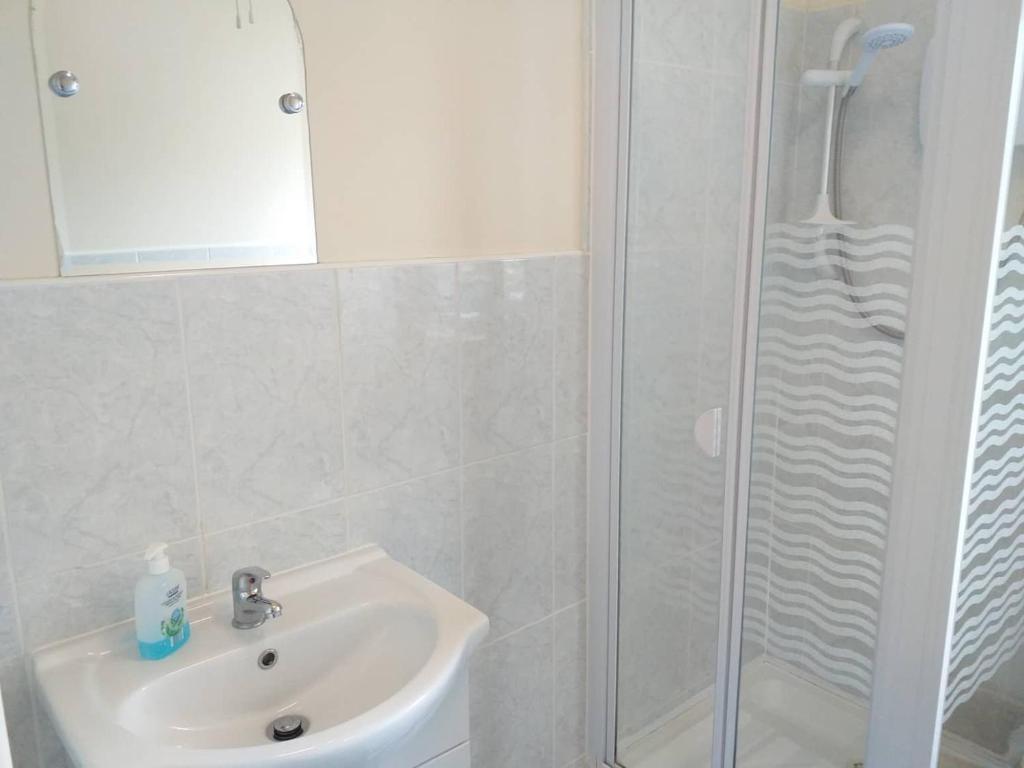 a white bathroom with a sink and a shower at Nick & Sandra's in Slane