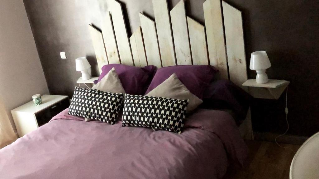 a bed with pillows on it in a bedroom at Chambre et table d hotes chez Dom in Sainte-Cécile-les-Vignes