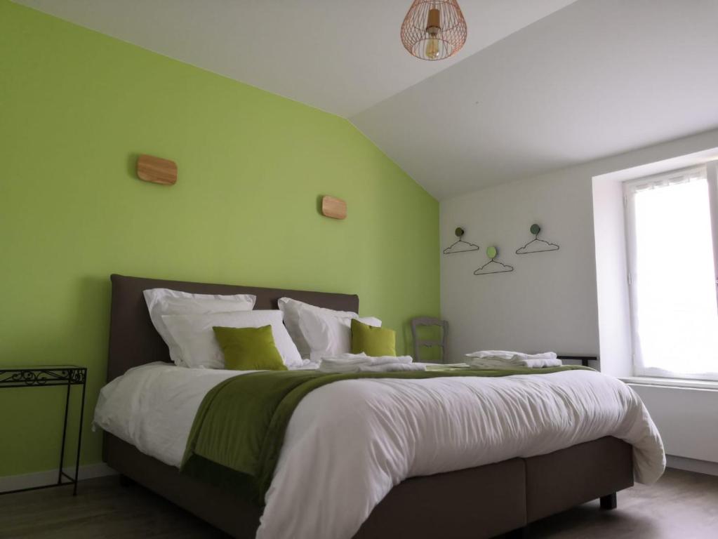 sypialnia z łóżkiem z zielonymi ścianami i oknem w obiekcie Gîte LES ARMINAUX w mieście Remilly-les-Pothées