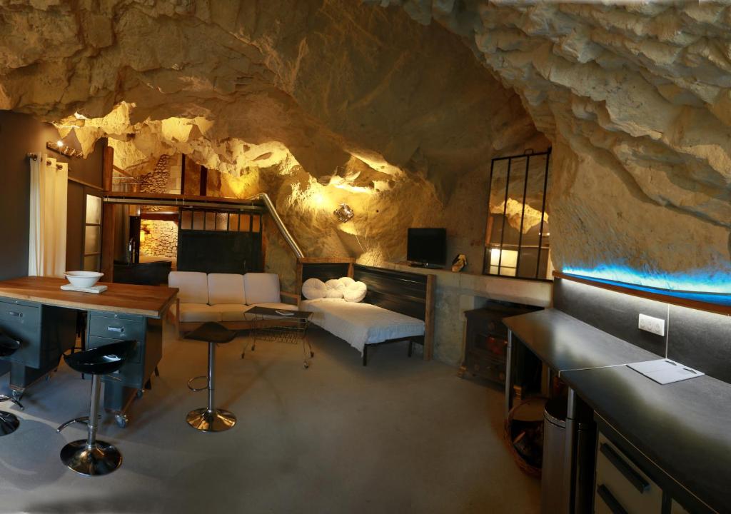 Zimmer in einer Höhle mit einem Schreibtisch und einem Sofa in der Unterkunft La Grotte du Moulin in Noyers-sur-Cher