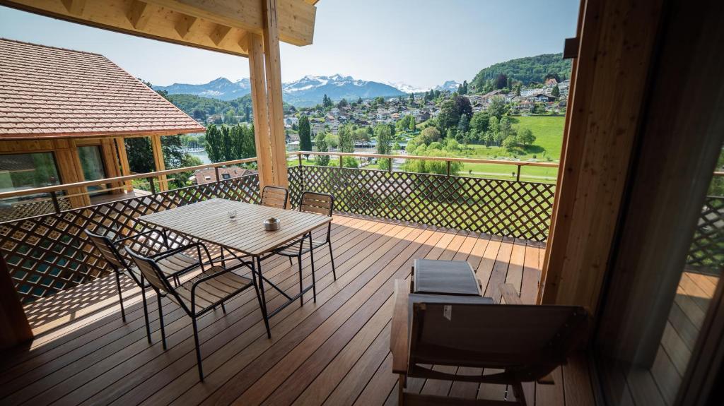 a wooden deck with a table and chairs on a balcony at Seaside-Lodge, Top Apartment in Spiez