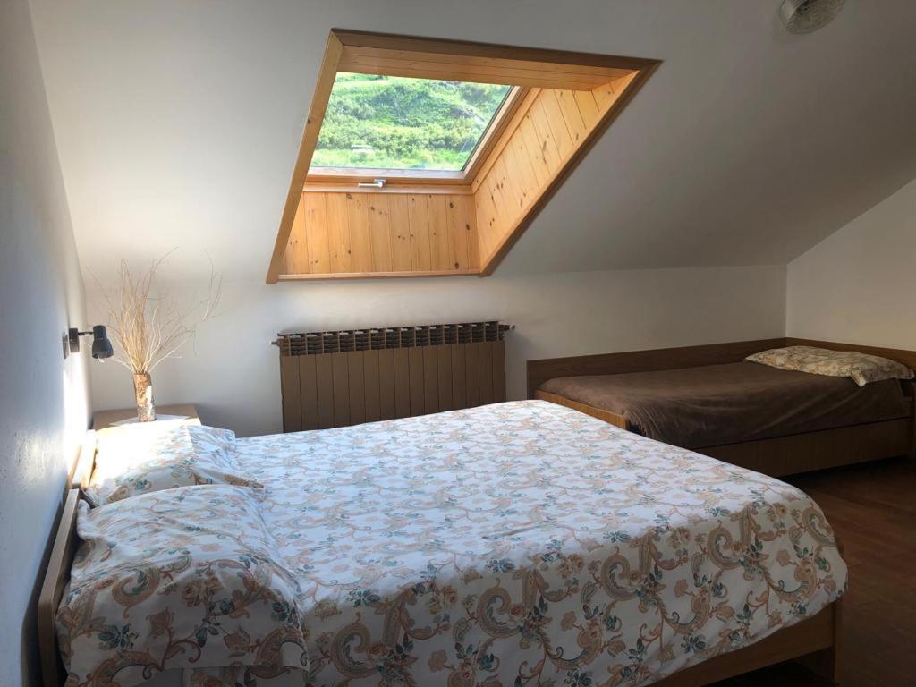 niewielka sypialnia z łóżkiem i oknem w obiekcie Residence Ables w mieście Valfurva
