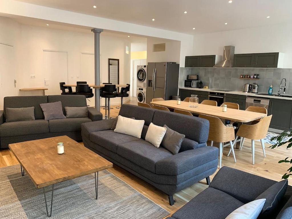 un salon avec des canapés et une table ainsi qu'une cuisine dans l'établissement My Trip in Paris - Temple, à Paris