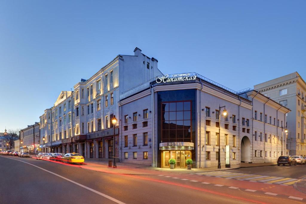 a building on a street with cars parked on the street at Assambleya Nikitskaya in Moscow