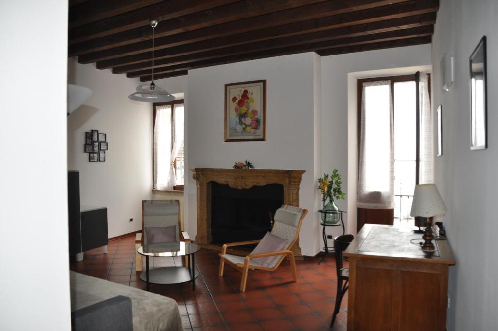 ein Wohnzimmer mit einem Kamin, einem Tisch und Stühlen in der Unterkunft Appartamento Le Volte in Toscolano-Maderno