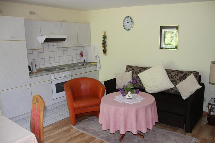 a living room with a table and a couch and a kitchen at Apartment Baden Baden Haus am Ibachweg in Baden-Baden