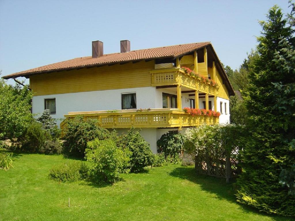 une maison avec un balcon au-dessus d'une cour dans l'établissement Pension Steiger, à Bad Griesbach im Rottal