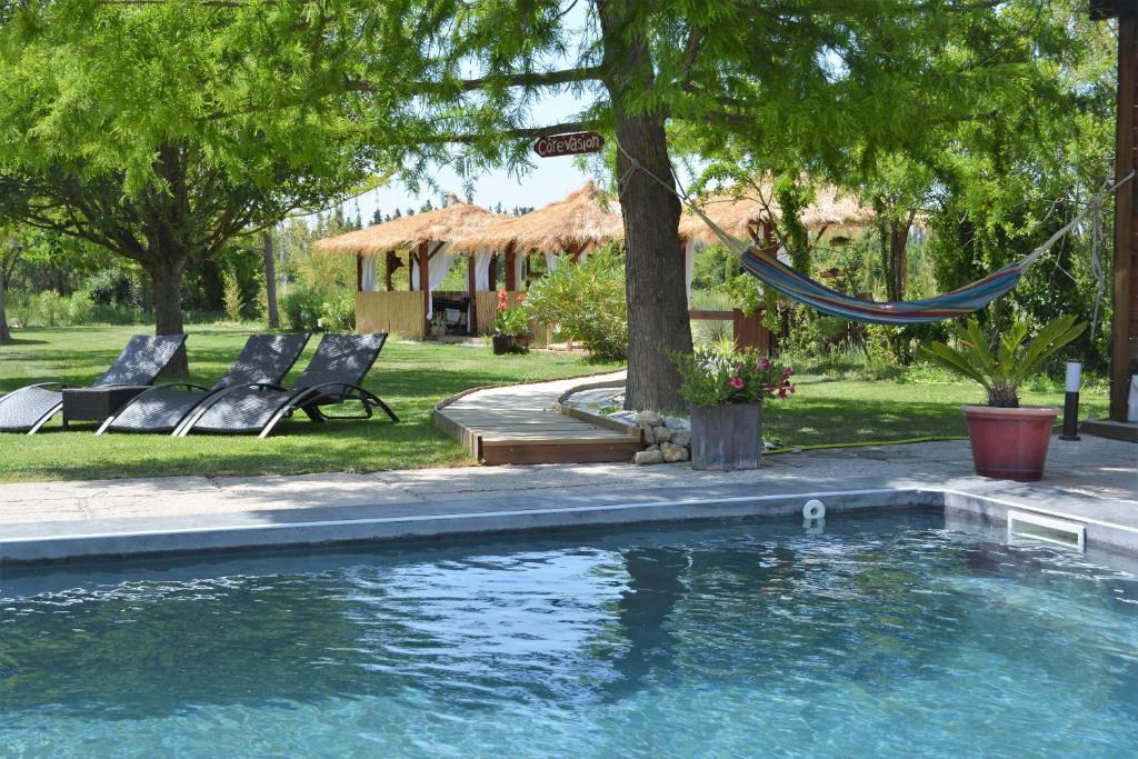 uma rede pendurada numa árvore junto a uma piscina em Lavand'Ange et SPA em Sarrians