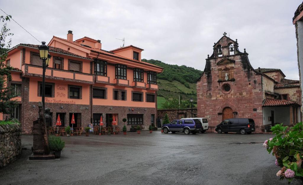 un edificio antiguo y un edificio con una torre de reloj en Hotel Restaurante Casa Pipo, en Tuña