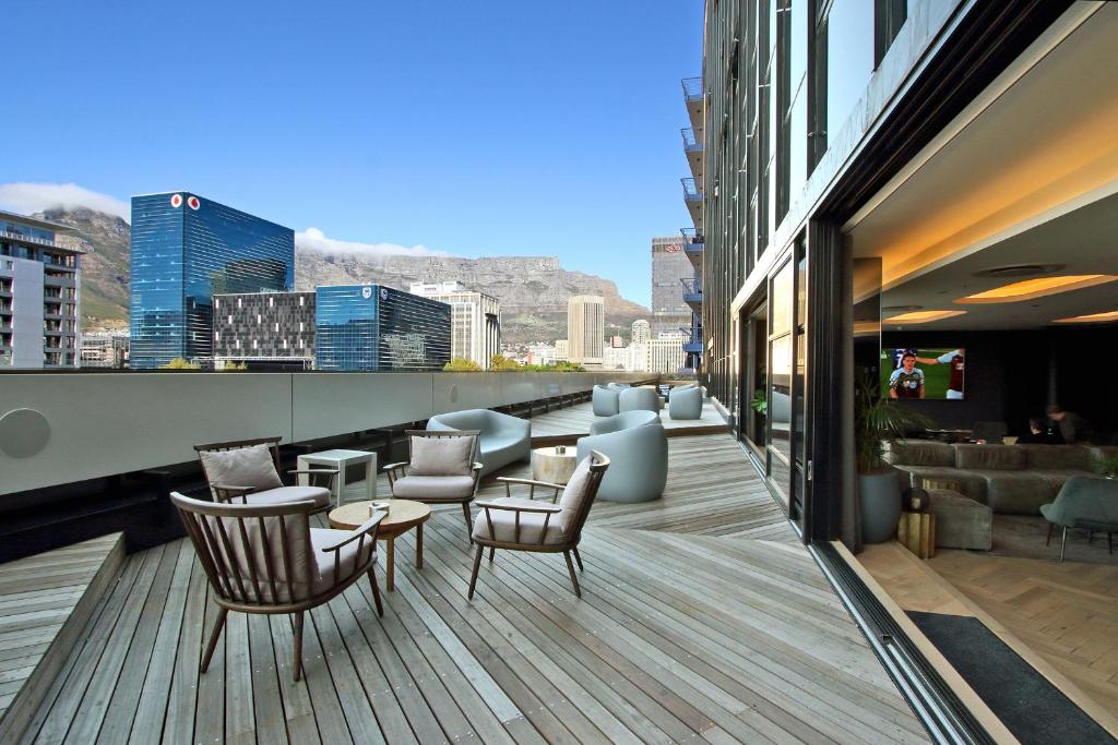 a balcony with chairs and tables on a building at Penthouse Henning@The Onyx in Cape Town