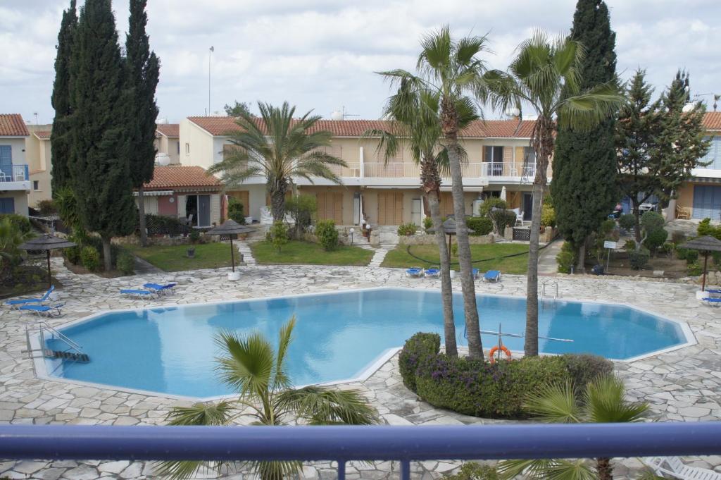 une piscine avec des palmiers devant un immeuble dans l'établissement Family Paradise- luxury combined with home comfort, à Paphos