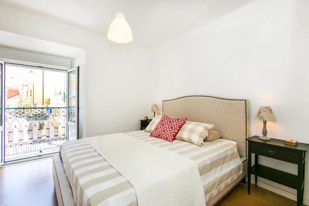 - une chambre blanche avec un lit et un balcon dans l'établissement Belem! Charming 2 Bedroom Apartment w terrace, Wifi & free street parking, à Lisbonne