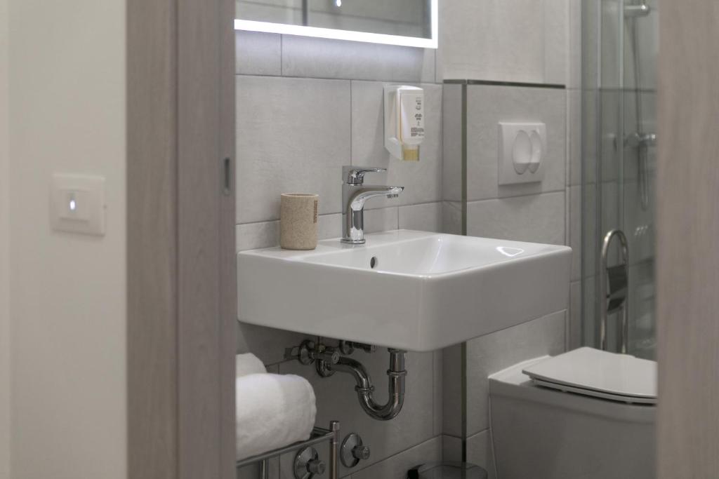 a white bathroom with a sink and a toilet at Preziosa in Pula