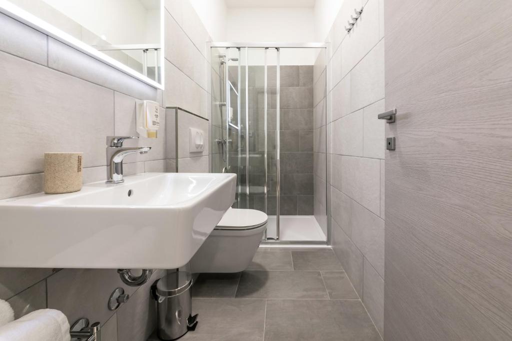 a bathroom with a sink and a toilet and a shower at Preziosa in Pula