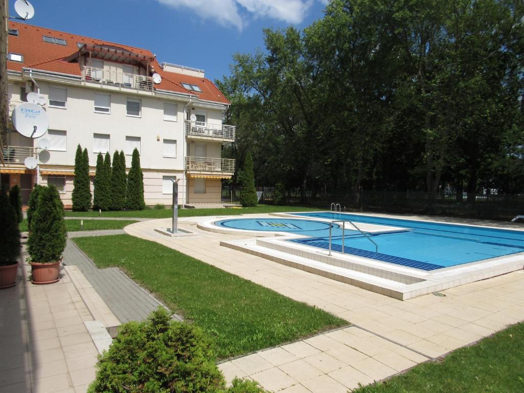 een zwembad in een tuin naast een gebouw bij Carpe Diem Apartment in Hajdúszoboszló