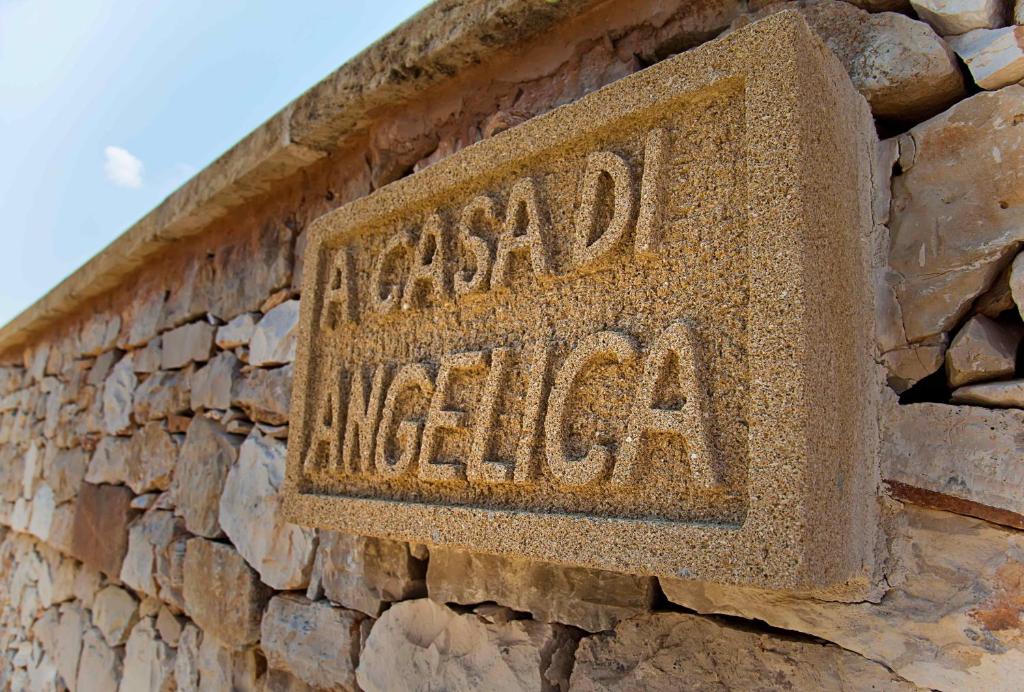 un panneau sur le côté d'un mur de pierre dans l'établissement "Casa di Angelica" - un'oasi di pace a 300m dal mare, à Gallipoli