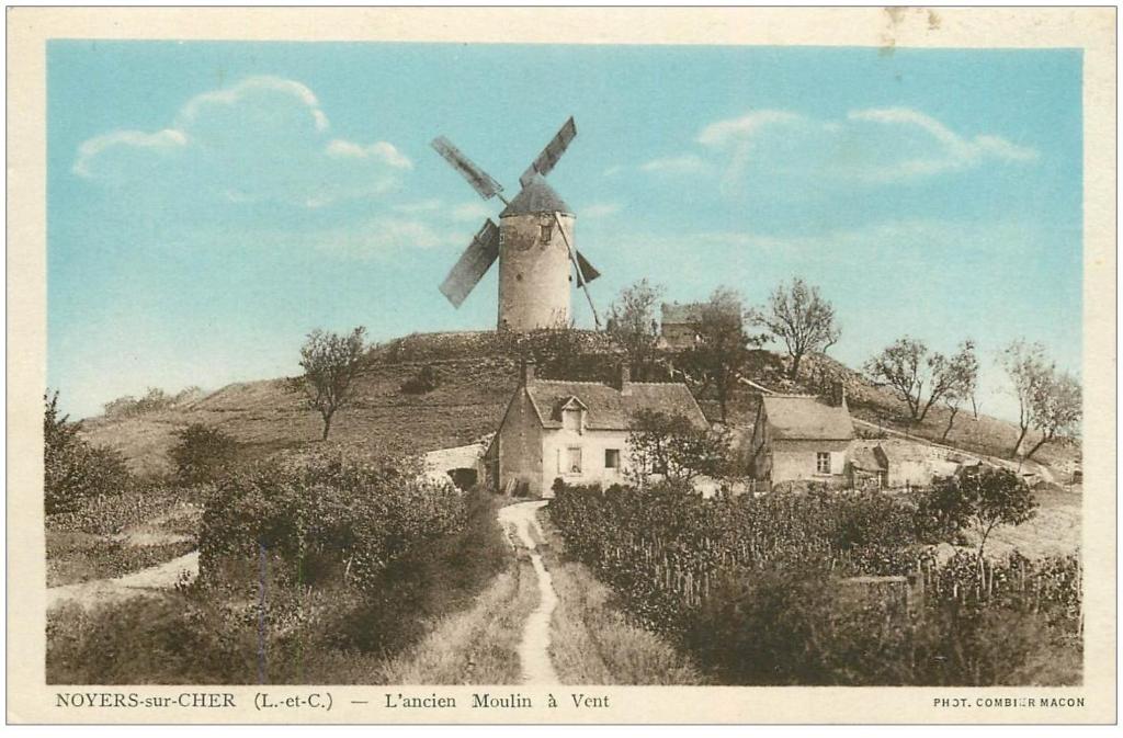 a black and white photo of a windmill on a hill at Le Moulin de la Motte Baudoin in Noyers-sur-Cher