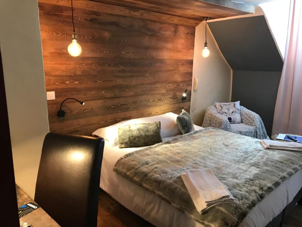 una camera con un letto e una parete in legno di Auberge de la Paix a Briançon