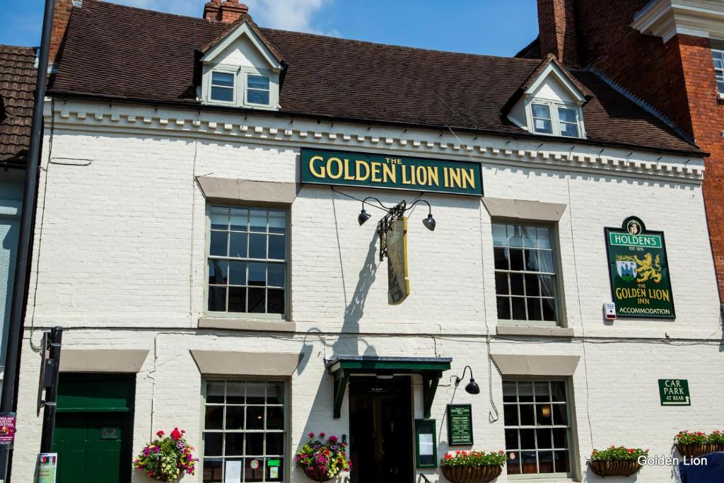 un edificio blanco con una posada de leones dorados. en The Golden Lion Inn en Bridgnorth