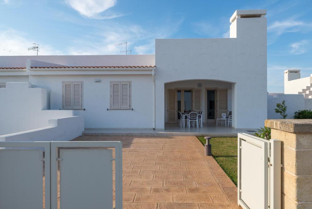 a white house with a porch and a patio at Blue Sea Villas by Wonderful Italy in Ostuni