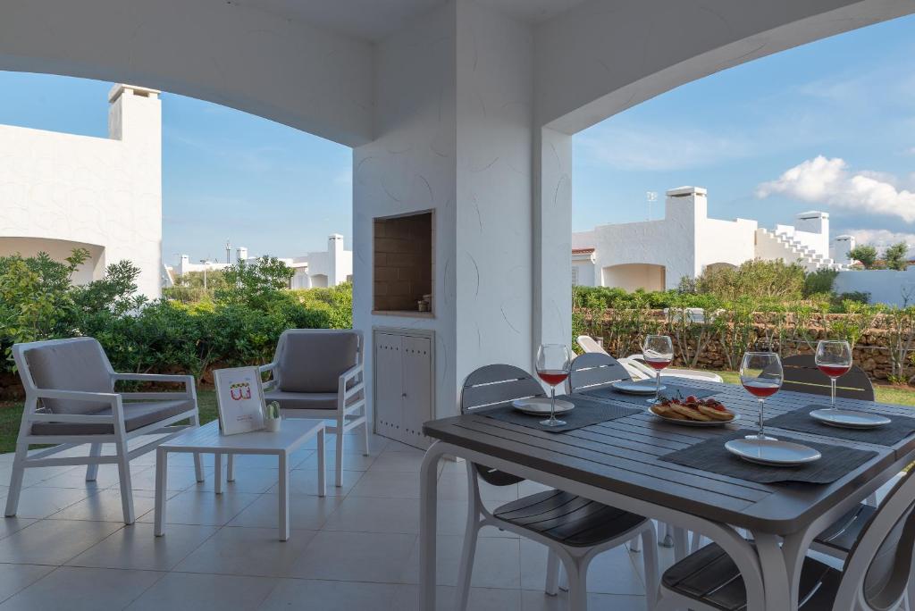 a table with wine glasses and chairs on a patio at Blue Sea Villas by Wonderful Italy in Ostuni