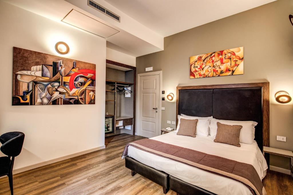 a bedroom with a bed and a painting on the wall at Al Manthia Hotel - Gruppo Trevi Hotels in Rome