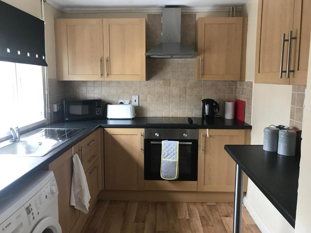 a kitchen with wooden cabinets and a stove top oven at 8 Pickering Road in Telford