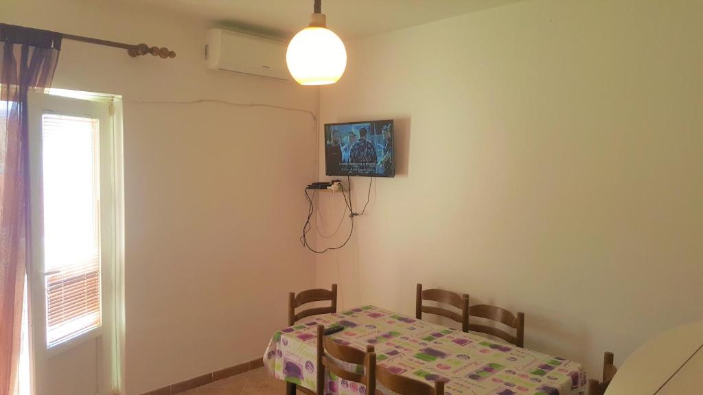 a table and chairs in a room with a table and a window at Apartments Niko Metajna, island Pag in Metajna