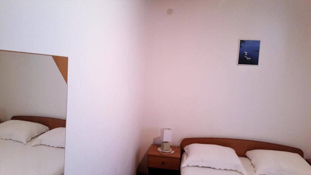 a bedroom with two beds and a mirror at Apartments Niko Metajna, island Pag in Metajna