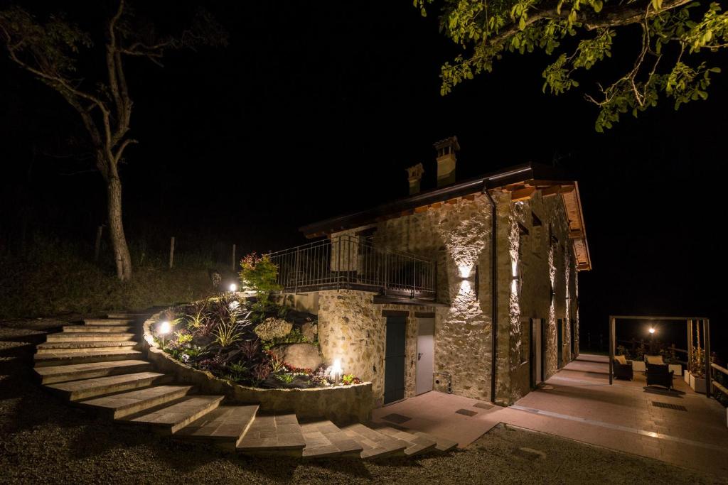 a stone building with stairs and lights at night at Agriturismo Casarai in Zone