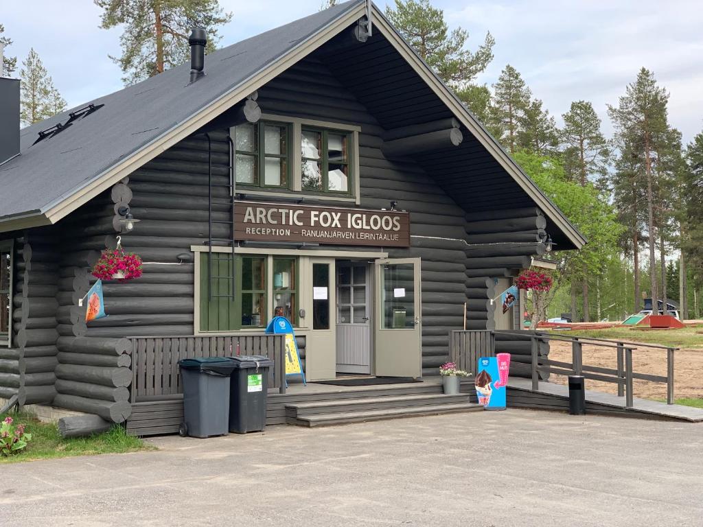 un edificio de madera con entrada a un lodge de zorros árticos en Ranua Resort Camping Ranuanjärvi en Ranua