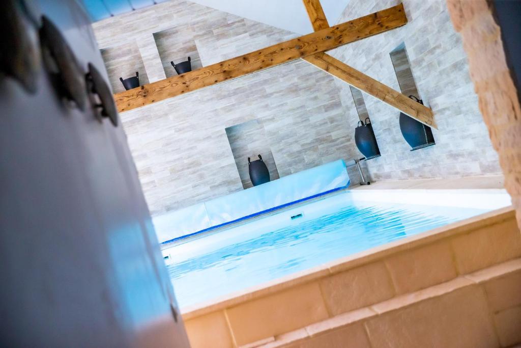 Habitación con bañera grande con agua azul. en La Ferme de L'Oudon & SPA, en Berville