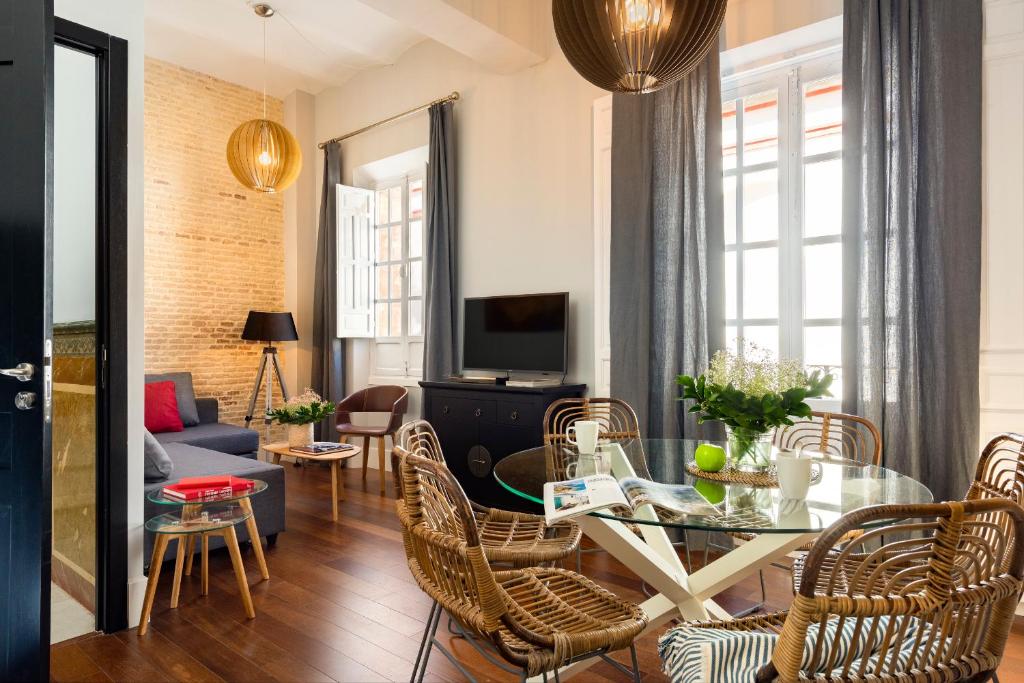 sala de estar con mesa de cristal y sillas en Imperial Luxury & Modern Apartment en Sevilla