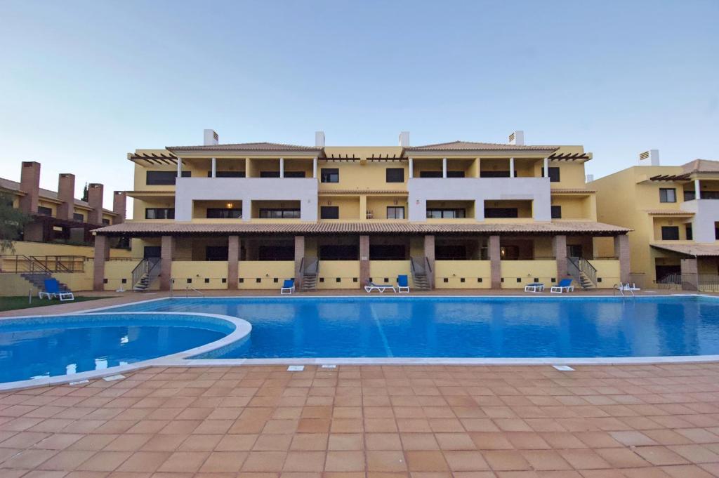 a swimming pool in front of a building at Vilamoura Condominio do Pinhal in Vilamoura