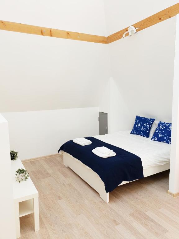 a bedroom with a bed with blue and white pillows at Vila G Palanga in Palanga